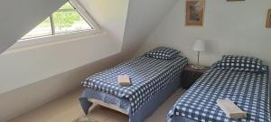 two twin beds in a room with a window at Luigeranna B&B in Küdema