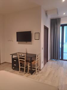 a dining room with a table and chairs and a television at Il Nido delle Cicogne in Sacca