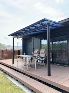 a pavilion with a table and chairs on a deck at -HITOTOKI- 家族とペットと他愛もないhitotokiを in Tsushi