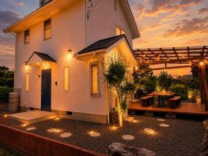a house with a patio and a table with lights at Biwa 広々テラス bbq 無料駐車場 湖まで徒歩3分 in Takashima