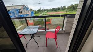 a balcony with two chairs and a table and a window at Ronglai Inn in Jinning