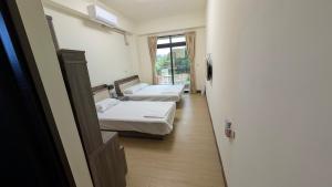 a hallway with two beds in a room at Ronglai Inn in Jinning