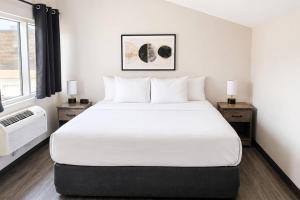 a bedroom with a large white bed and a window at Quality Inn & Suites in Gatineau