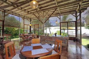 a dining room with tables and chairs and windows at Pondok Pisang Candidasa in Candidasa