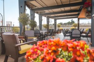 eine Außenterrasse mit Tischen, Stühlen und Blumen in der Unterkunft Hotel Keto in Podgorica