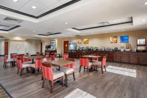 a restaurant with tables and chairs and a bar at Comfort Inn & Suites Clinton - Jackson West in Clinton