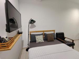 a bedroom with a bed and a flat screen tv at Suite Us Guesthouse Kubang Kerian in Kota Bharu