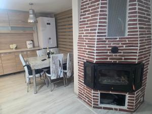a brick fireplace in a living room with a table at Къща Теяна in Tryavna
