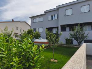 an apartment building with a yard with plants at Apartman Varea in Ližnjan