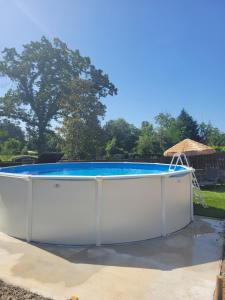 a pool in a yard with a white poolvisor at Gite piscine privée climatisation in Célon
