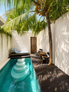 a swimming pool with a palm tree next to a house at Eve Evy Private Pool Villas in Nusa Lembongan