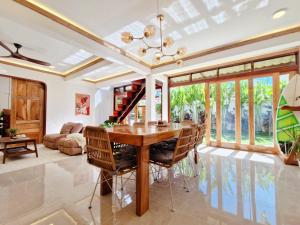 a dining room with a wooden table and chairs at Three-Bedroom Luxury Garden Villa by Sing Siargao in General Luna