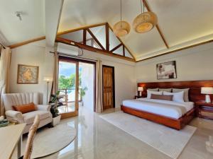 a bedroom with a king sized bed and a desk at Three-Bedroom Luxury Garden Villa by Sing Siargao in General Luna +37 photos