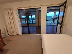 a bedroom with a bed and a door to a balcony at Apartment 2 in Auckland
