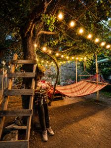a woman standing next to a hammock under a tree at Sheki Secret Garden Boutique Hotel & Guest House in Sheki +115 photos