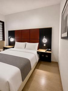 a bedroom with a large bed and two lamps at INOH Athens Hotel in Athens