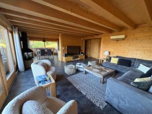 a large living room with couches and a table at Chalet La Renarde in Villars-sur-Ollon