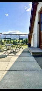 a group of chairs sitting on a porch of a building at The Studio at Torr Leathann - Modern Studio in Stittenham