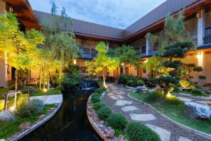 a building with a river in front of a building at Towa Onsen and Ryokan in Ban Nong Tangme