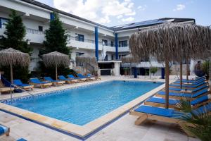 a swimming pool with blue chairs and umbrellas at Blue Border in Vama Veche