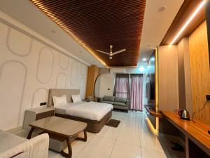 a hotel room with a bed and a living room at Nagarkoti Residency Inn in Pithorāgarh