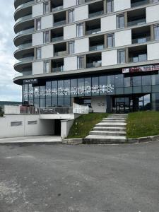 a large apartment building with stairs in front of it at Dana Residence in Floreşti