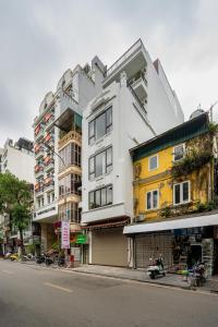 a tall white building on the side of a street at Gao House in Hanoi
