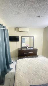 a room with a bed and a mirror and a window at Villa lux in Portmore