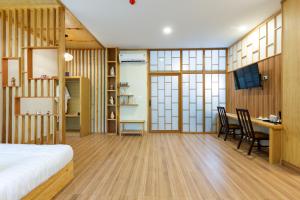 a bedroom with a bed and a desk and a table at Towa Onsen and Ryokan in Ban Nong Tangme