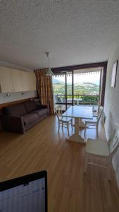 a living room with a table and a couch at Résidence Serre-Ponçon in Chorges +14 photos