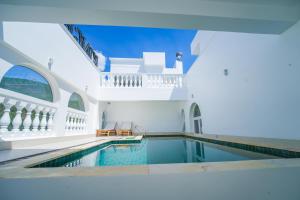 an indoor swimming pool in a white house at King Hotel in Quy Nhon