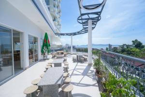 a balcony with tables and chairs on a building at King Hotel in Quy Nhon