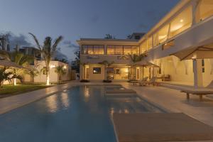 a large house with a swimming pool in front of it at Tawi Elegant Rooms - Watamu in Watamu