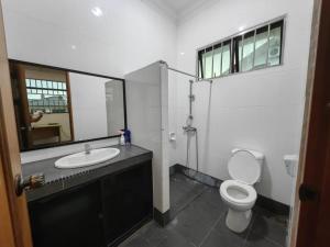 a bathroom with a toilet and a sink and a mirror at Stay181 Bintulu in Bintulu +1 photo