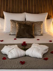 a bed with two towels and red roses on it at Appart&Spa Devosge in Dijon