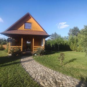a log cabin with a stone path in front of it at Jałowcowe Zacisze in Brody