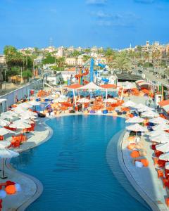 a swimming pool with umbrellas and chairs and a resort at جمصه Amoun Chalet Gamasa in Jamaşah