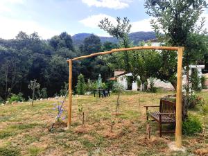 a bench in a field with a swing at Stone House Rooms near Kavala in Amisianá
