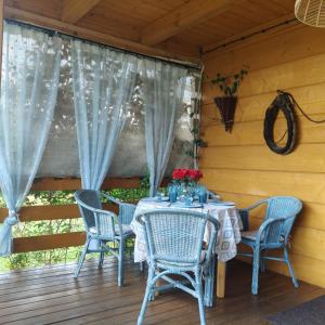 a table and chairs on the porch of a cabin at Jałowcowe Zacisze in Brody