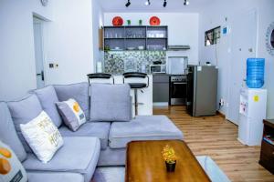 a living room with a blue couch and a kitchen at Tatu City Serene 2BR Apartment in Tatu City