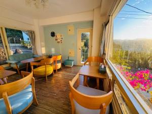 a restaurant with a table and chairs and a large window at 藍屋頂民宿Blue Dome in Puli