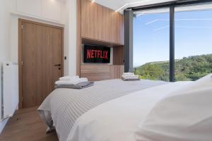 a bedroom with a bed with a tv on the wall at BlackPine Villa in Amisianá