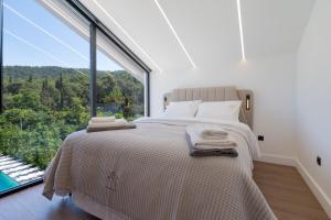 a bedroom with a bed in front of a large window at BlackPine Villa in Amisianá