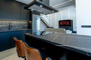 a kitchen with a black counter top and chairs at BlackPine Villa in Amisianá