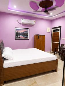 a bedroom with a bed and a purple wall at Bhagwan krishan kutir in Govardhan