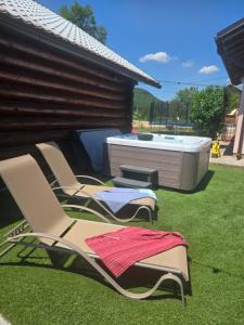 two lawn chairs and a hot tub in a yard at Kuća za odmor Brlog in Otočac