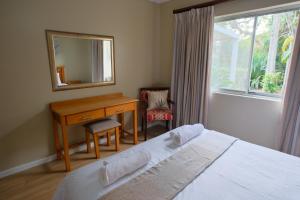 a bedroom with a bed and a desk and a mirror at Lakeview Cabanas - Unit 5 in St Lucia +33 photos