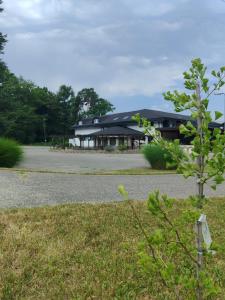 a black building with a tree in front of it at WoW sleeping in Miklavž na Dravskem Polju