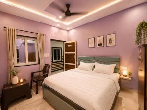 a bedroom with a bed and a purple wall at Bhagwan krishan kutir in Govardhan