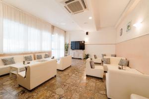 a waiting room with white furniture and a large window at Hotel Carol in Cesenatico